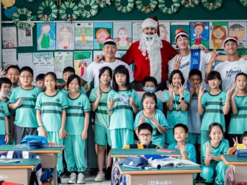 高雄全家海神隊「浪愛延續」到華山國小 洋將艾倫化身「聖誕老人」英文教學